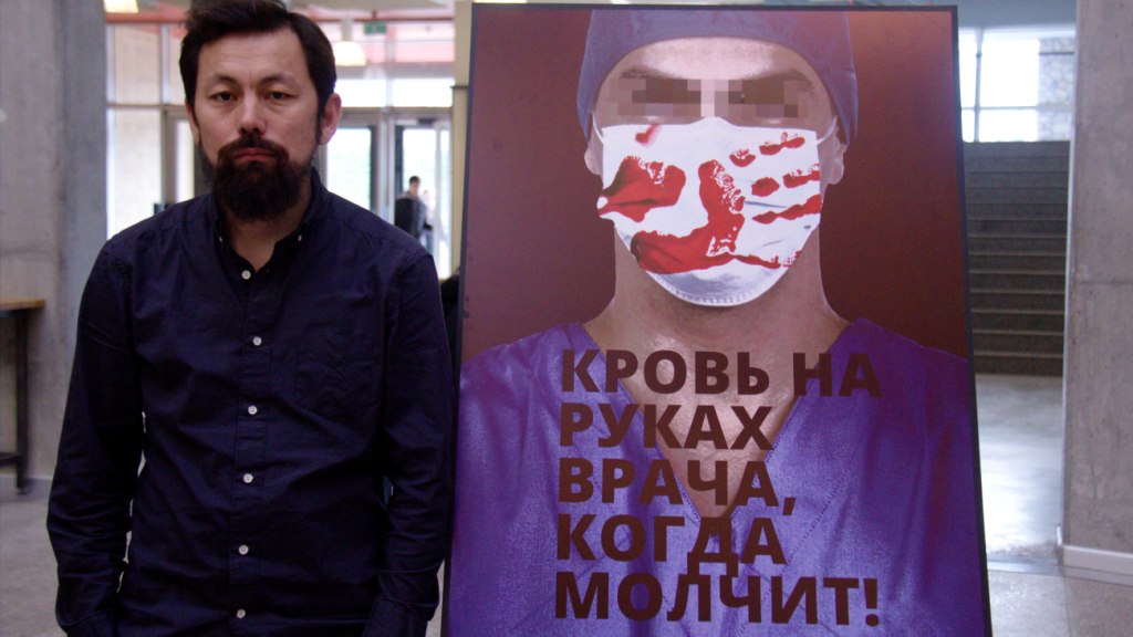Дизайнер Марсель Шейшенов өз плакаты менен.