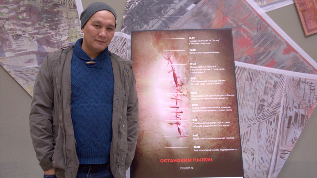 Дизайнер Нурбек Насыранбеков өз плакаты менен.